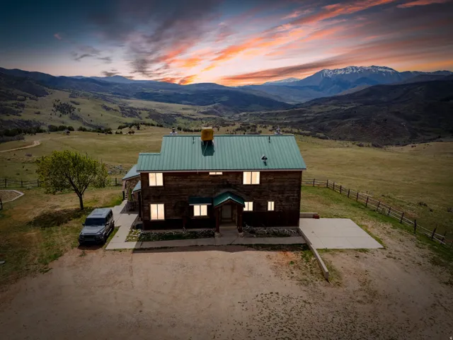 View of front facade featuring a metal roof, a view of countryside, a chimney, and a mountain view