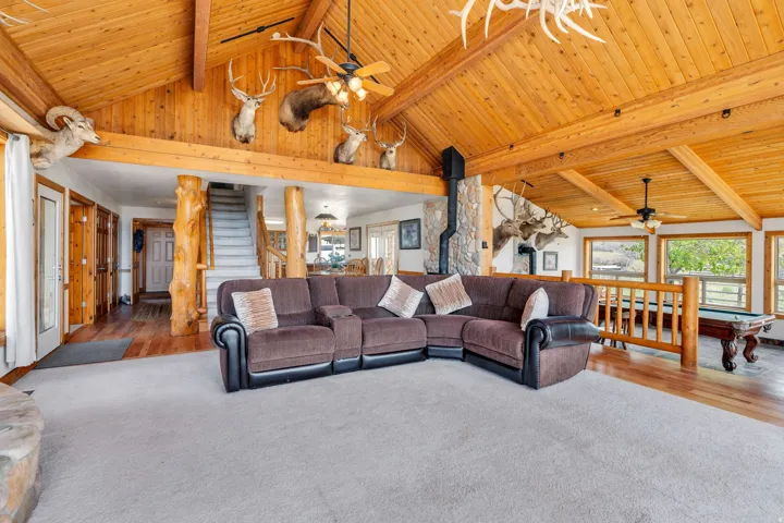 Living area featuring ceiling fan, a high wooden beamed ceiling, pool table, carpet, and wood finished floors