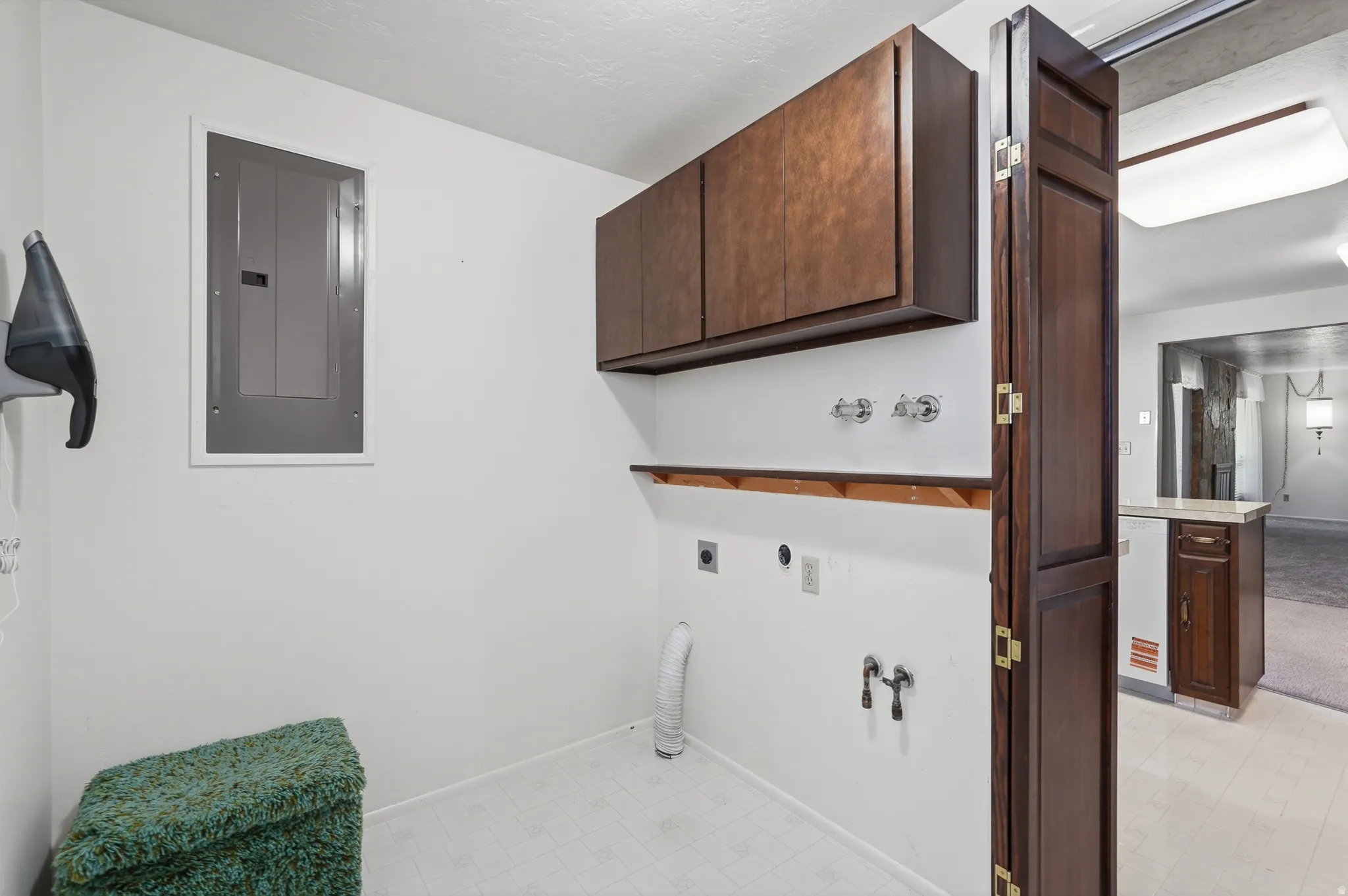 Laundry area featuring upper cabinetry, a built-in shelf, and appliance hookups
