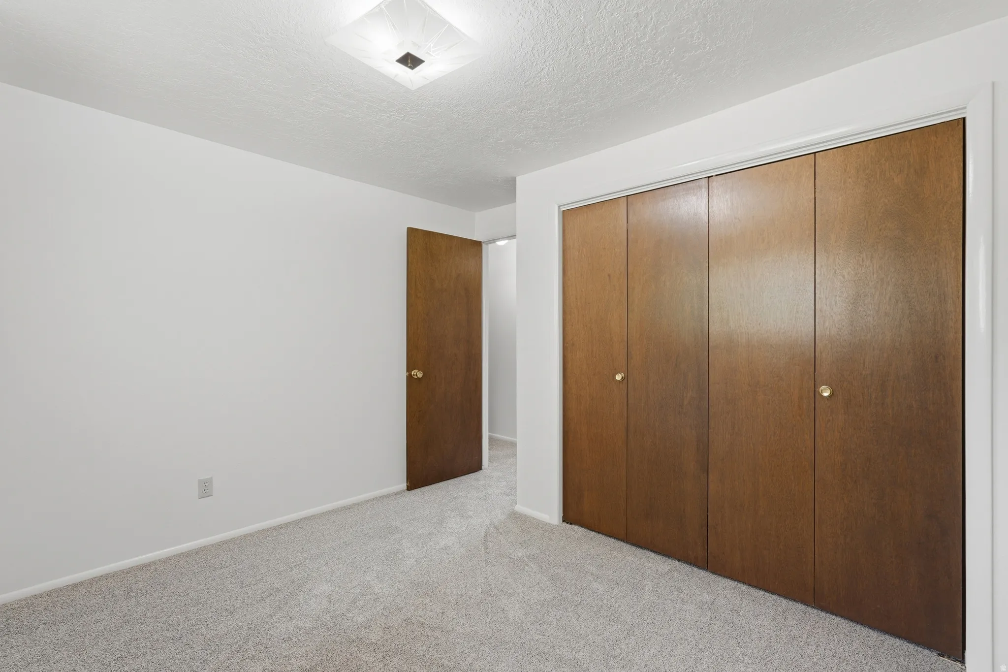 Bedroom featuring light-colored carpet flooring and white walls