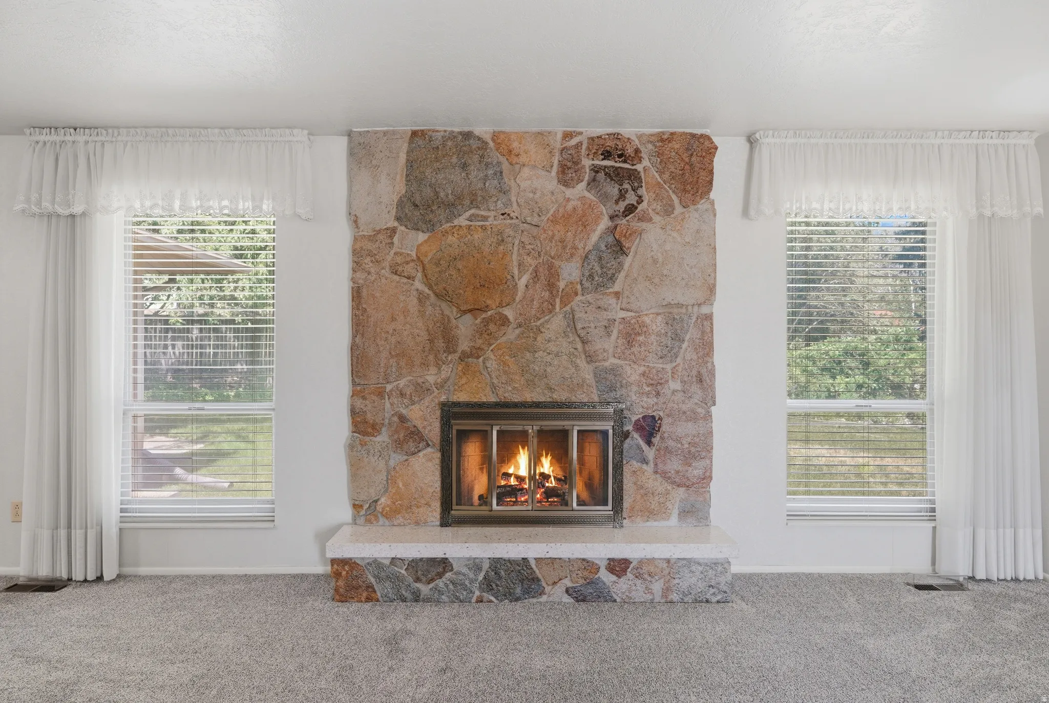 Full-height natural stone fireplace with a raised hearth