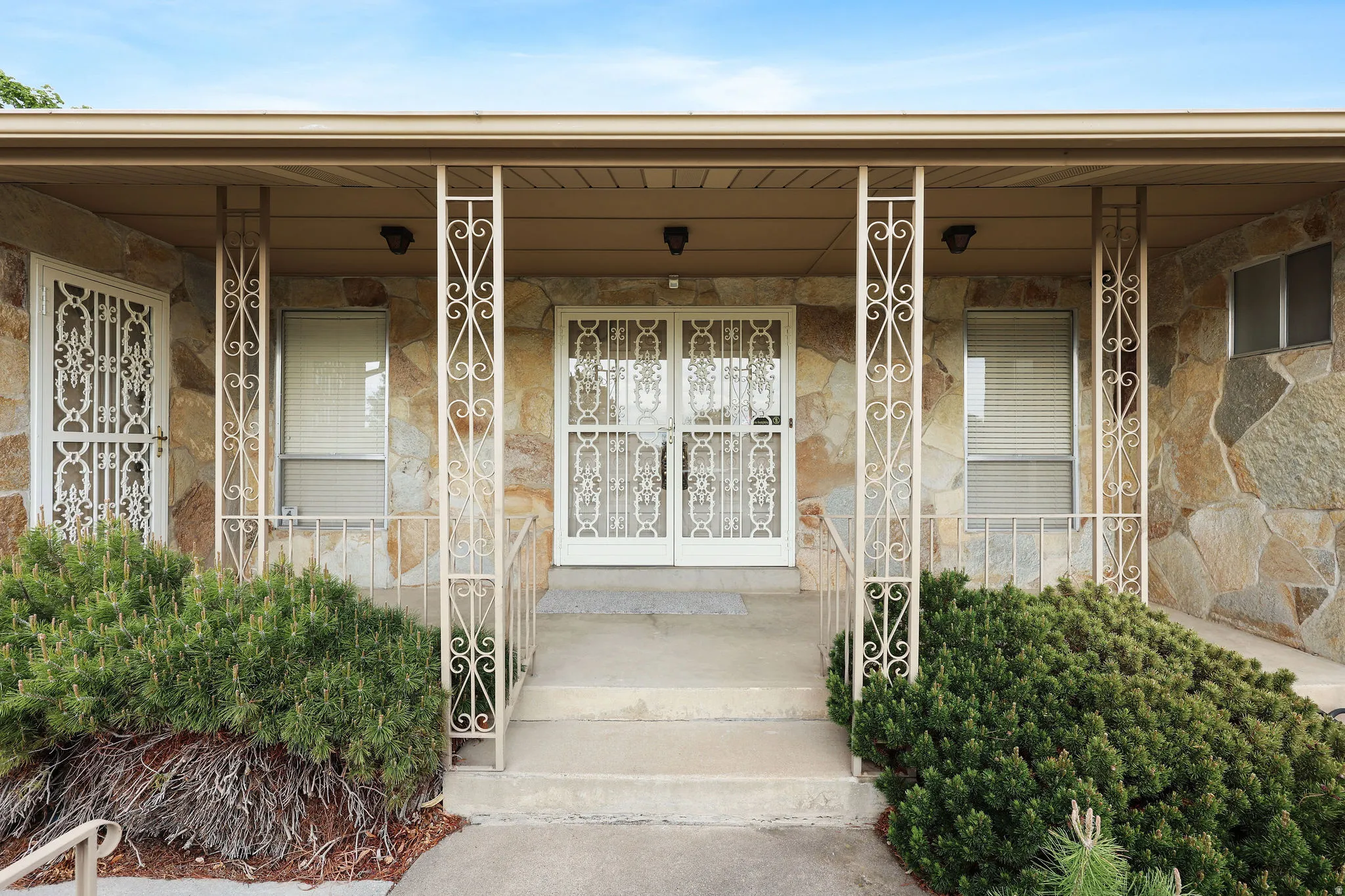 View of exterior entry featuring a porch and stone siding