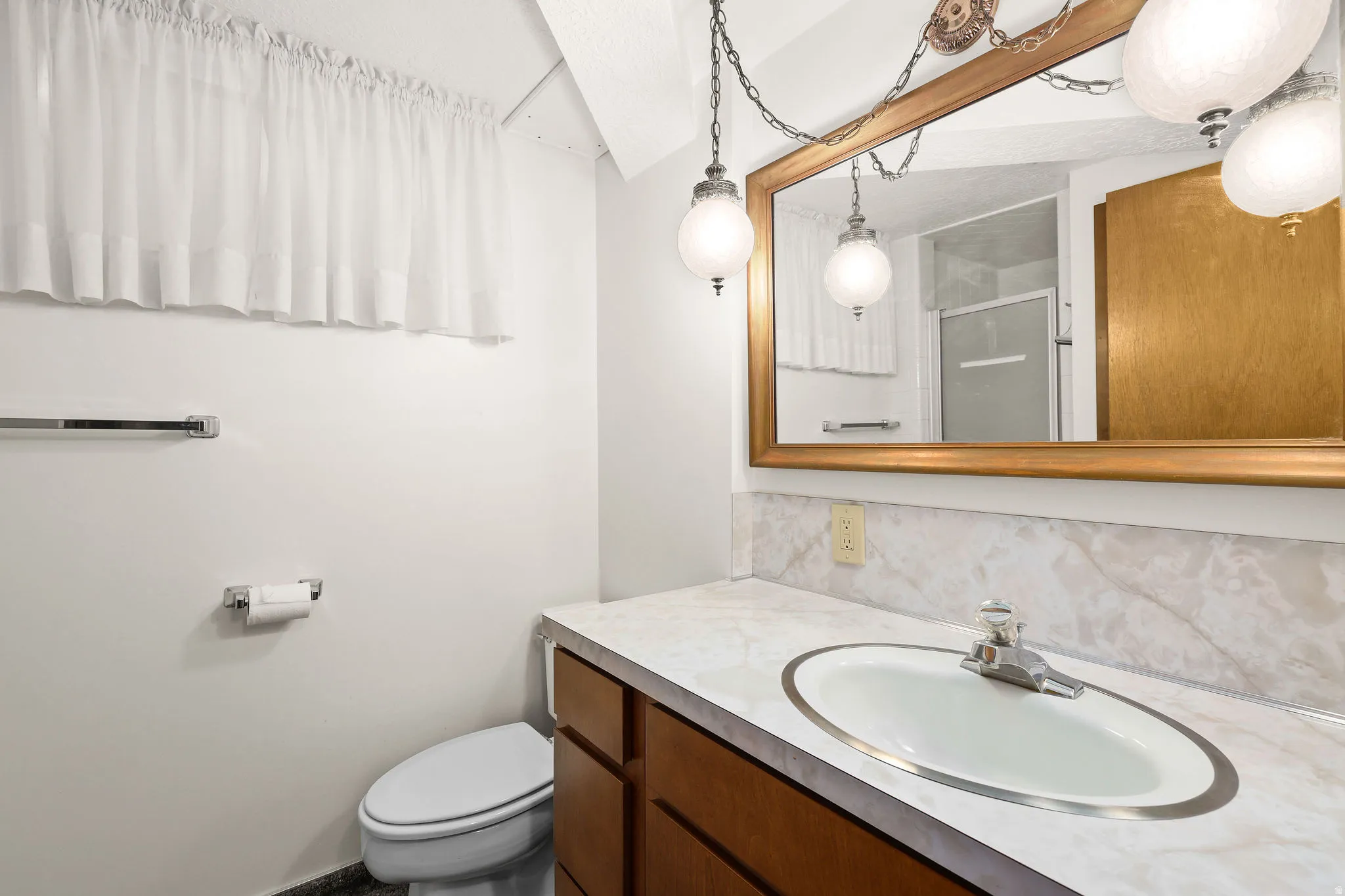 Bathroom with vanity, a stall shower, and backsplash