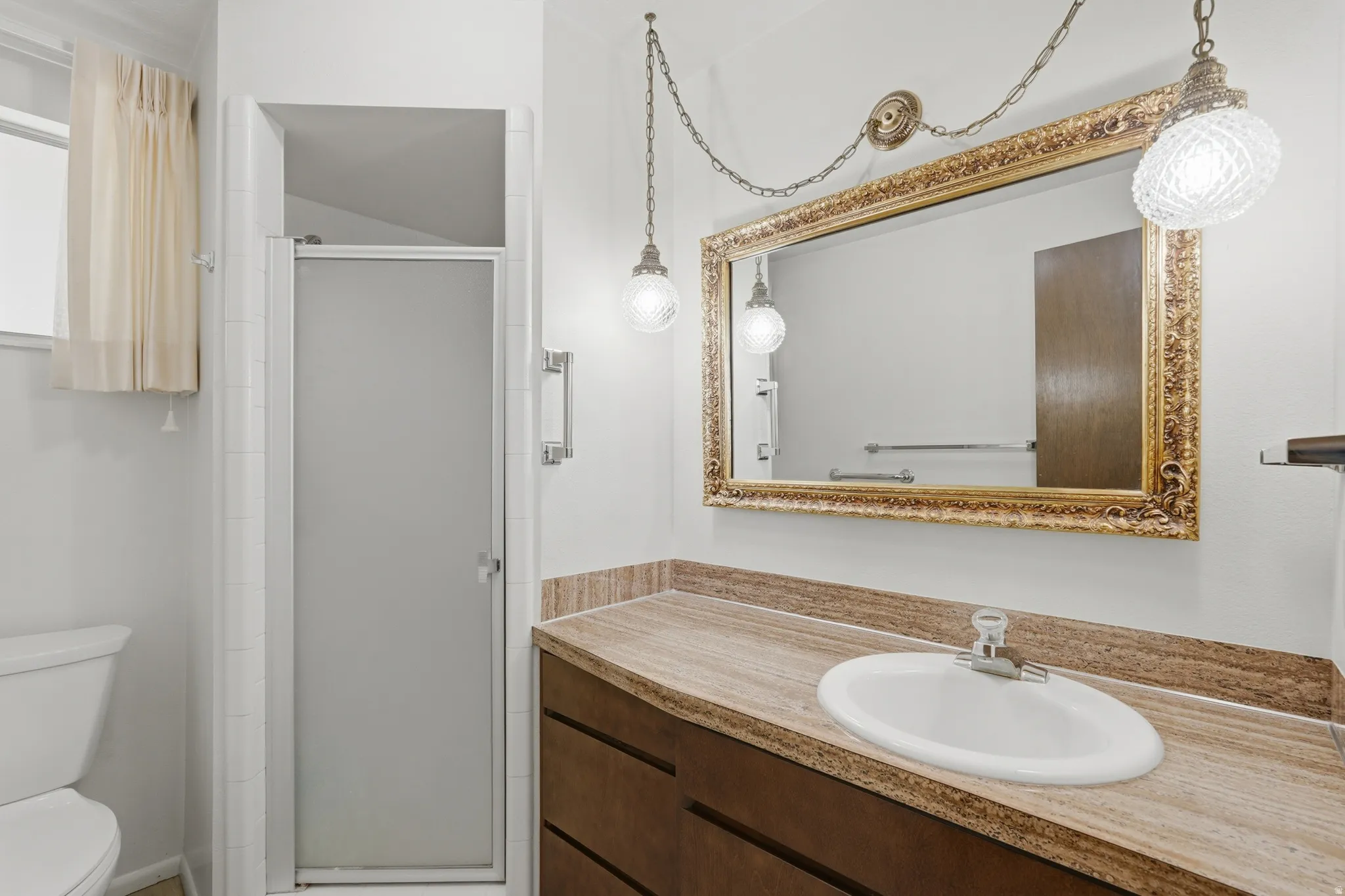 Bathroom vanity with a built-in sink, stone-finish countertop, and decorative mirror