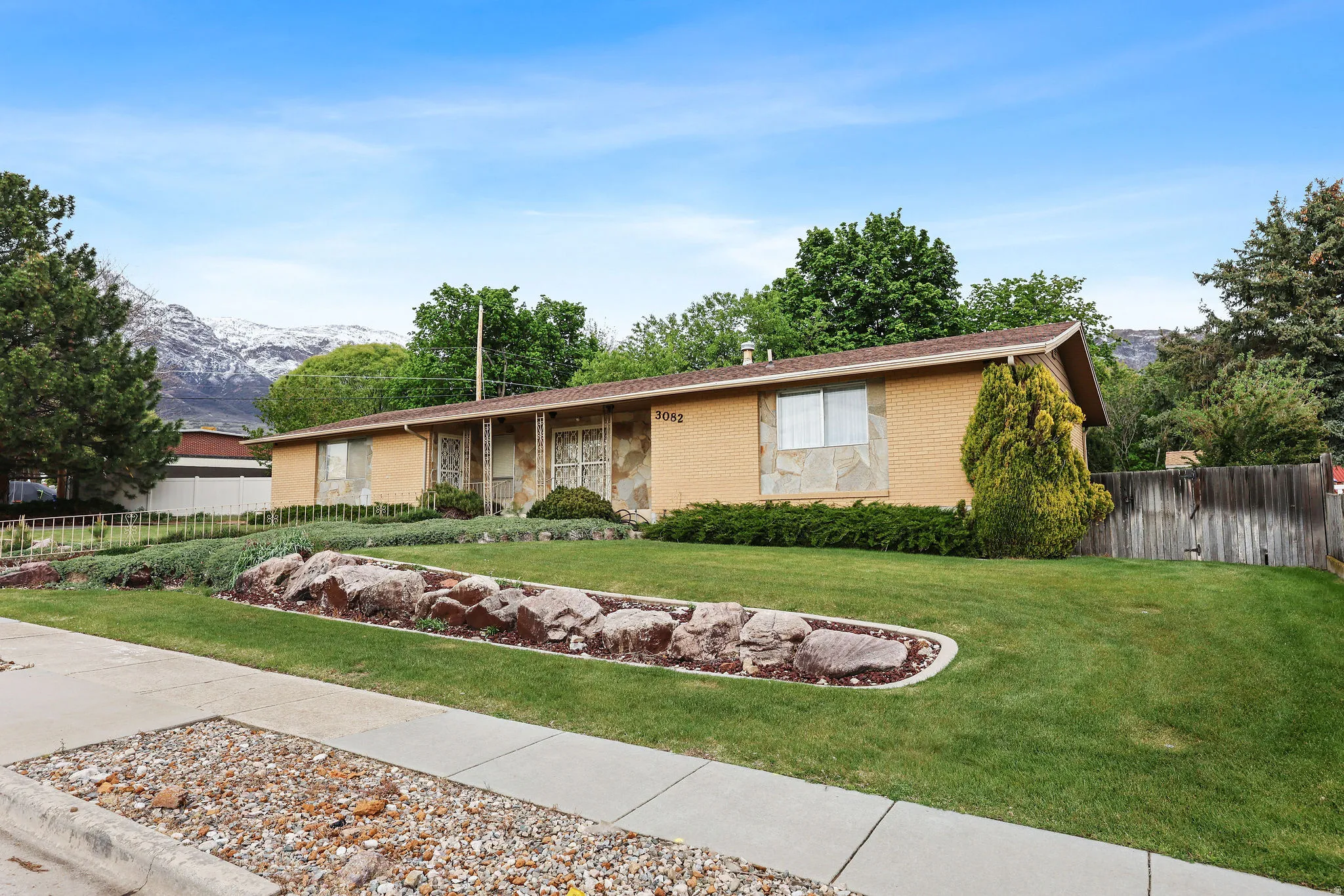 Ranch-style house with brick siding, a mountain view, and a porch
