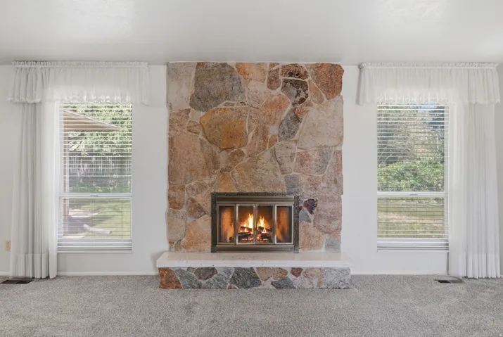 Full-height natural stone fireplace with a raised hearth