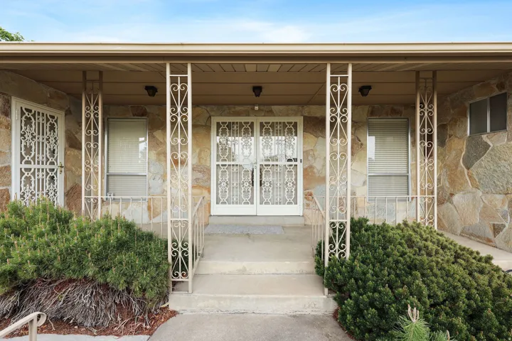 View of exterior entry featuring a porch and stone siding