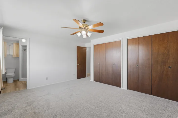 Spacious room featuring light-toned carpeting and a ceiling fan with integrated lighting
