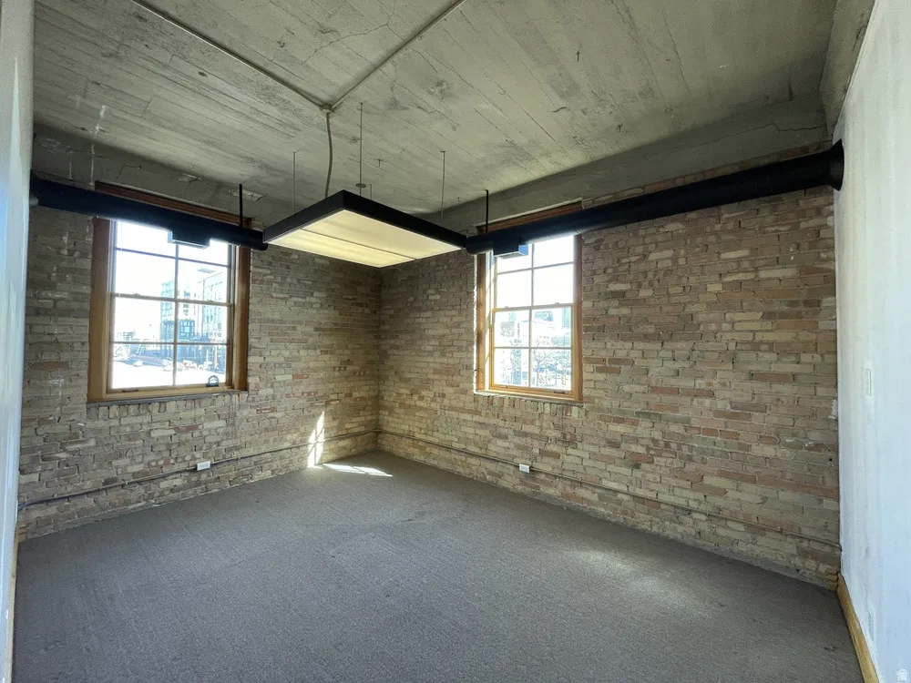 Carpeted empty room with brick wall