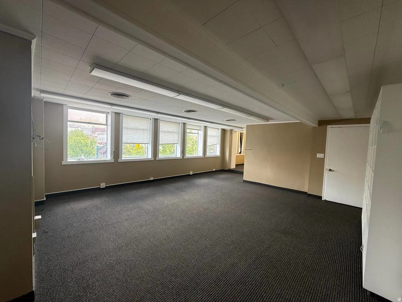 Spare room with dark carpet and baseboards