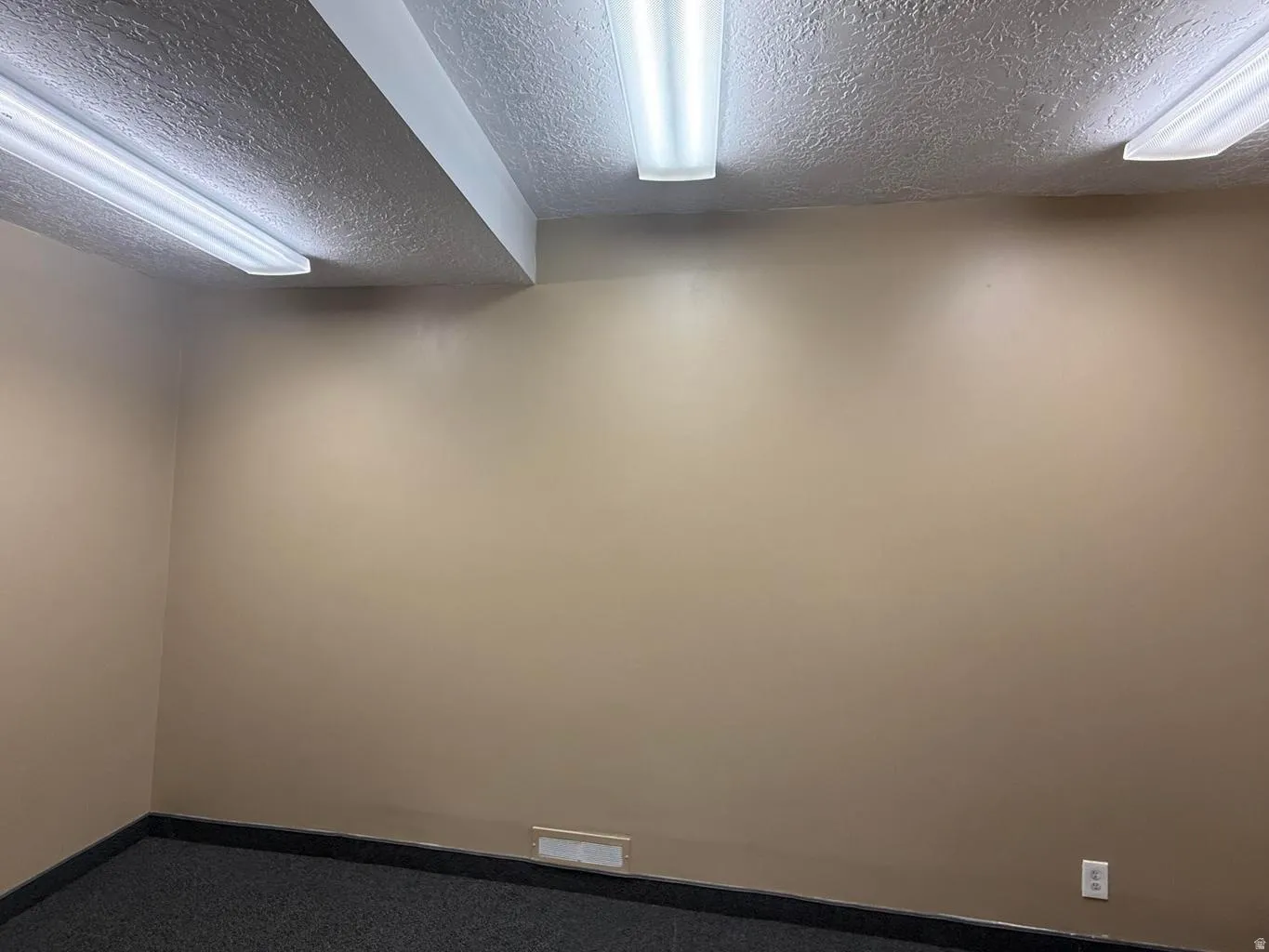 Spare room with a textured ceiling and carpet floors