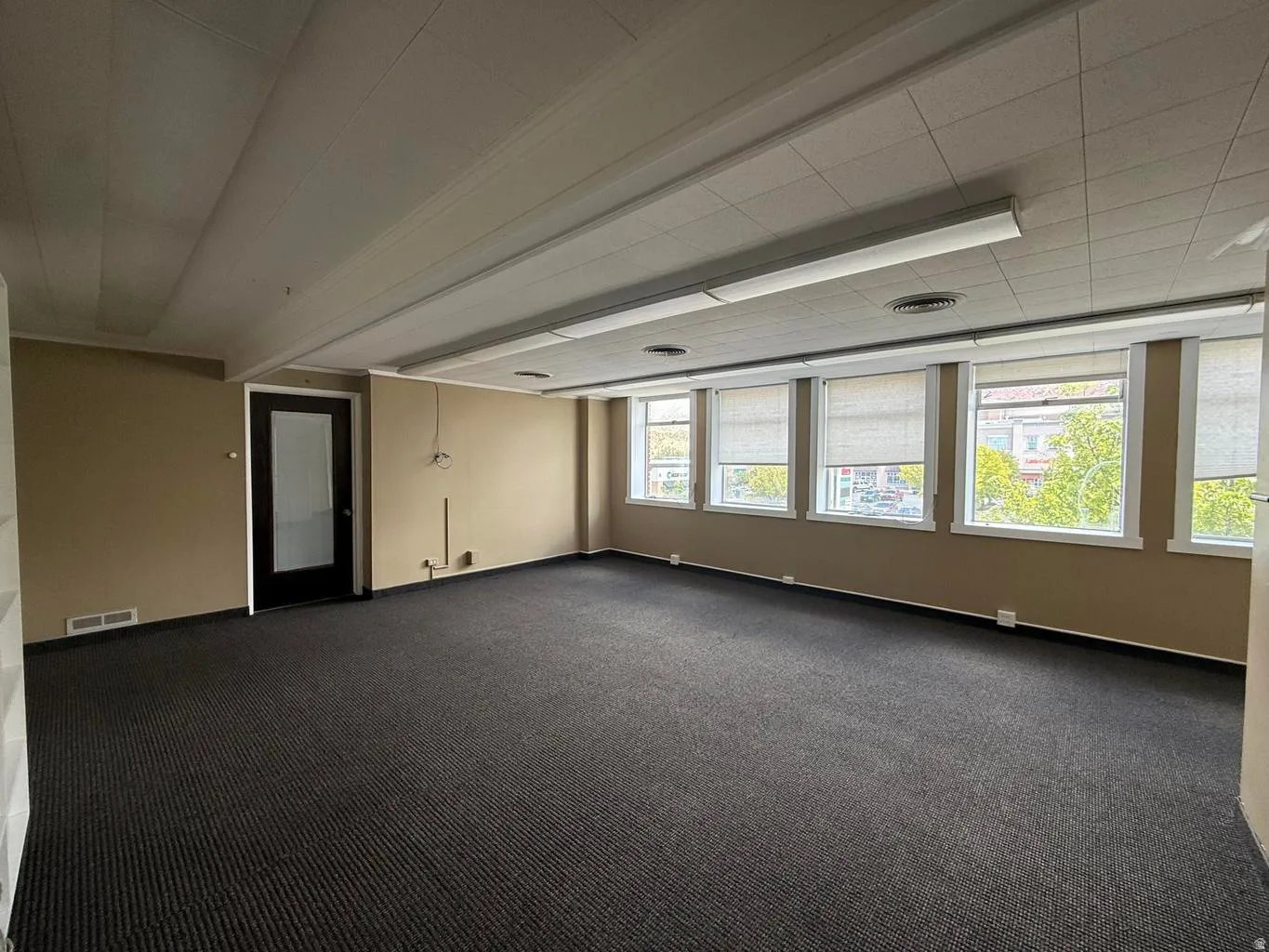 Empty room with dark carpet and baseboards