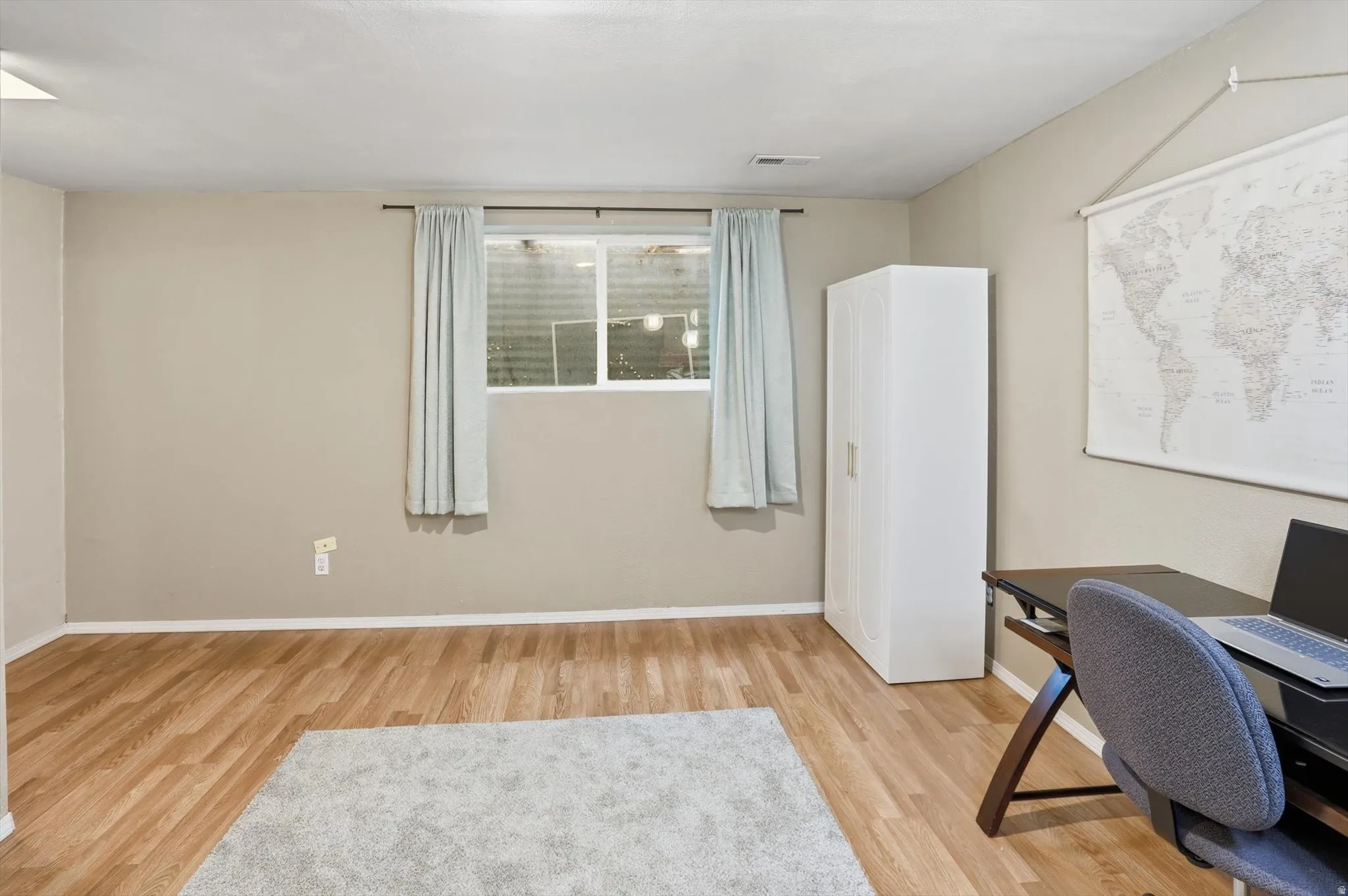 Home office with light wood-style floors and baseboards