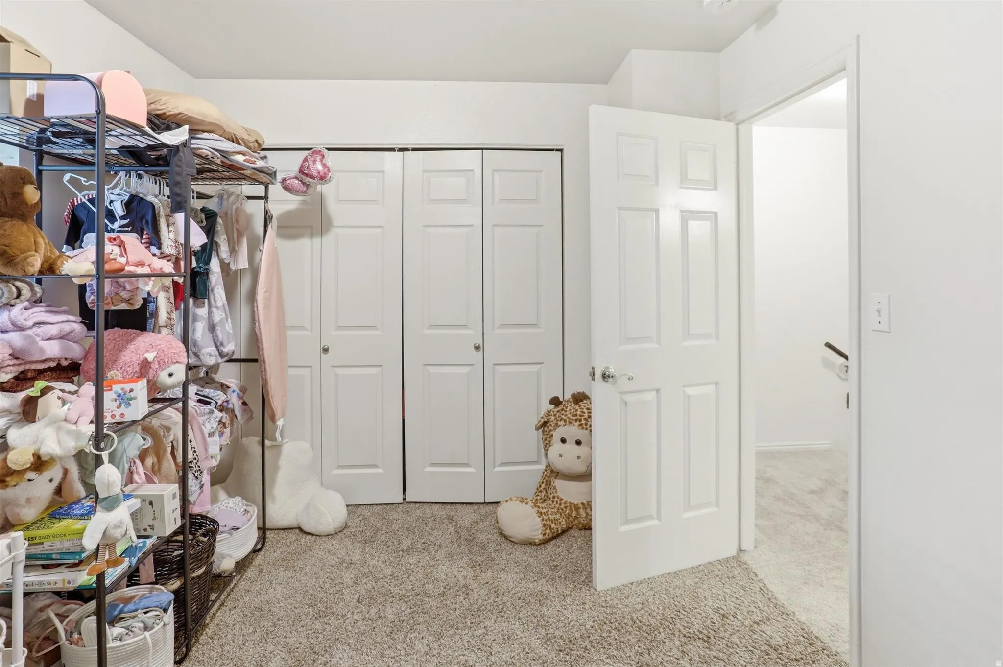 Walk in closet featuring light colored carpet