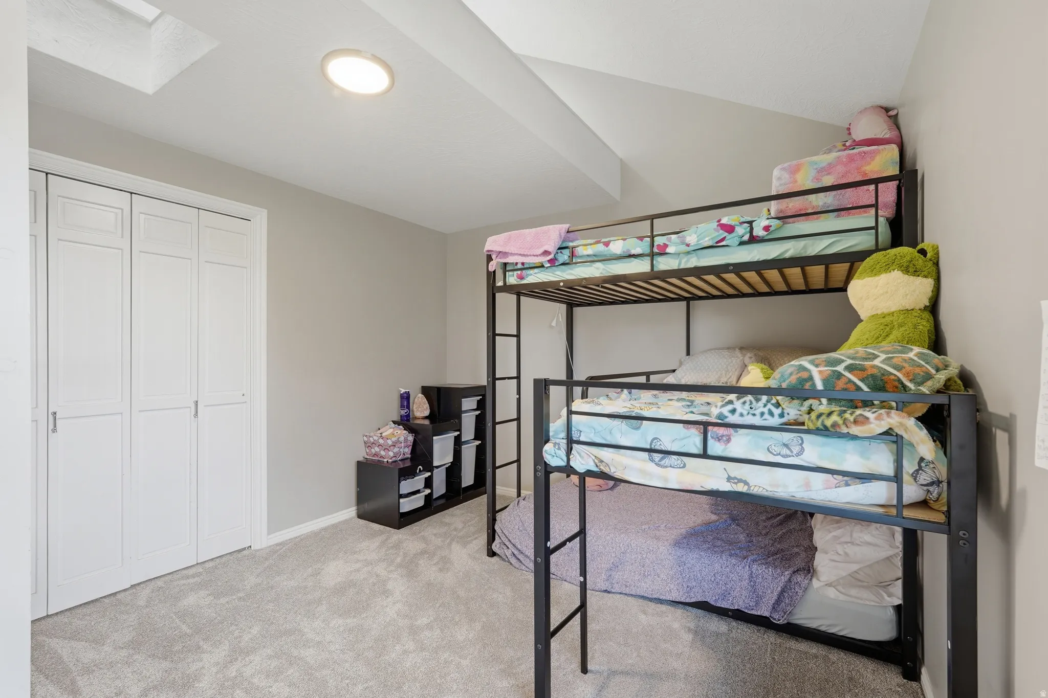 Bedroom featuring light carpet, Loft space above, vaulted ceiling, and a closet