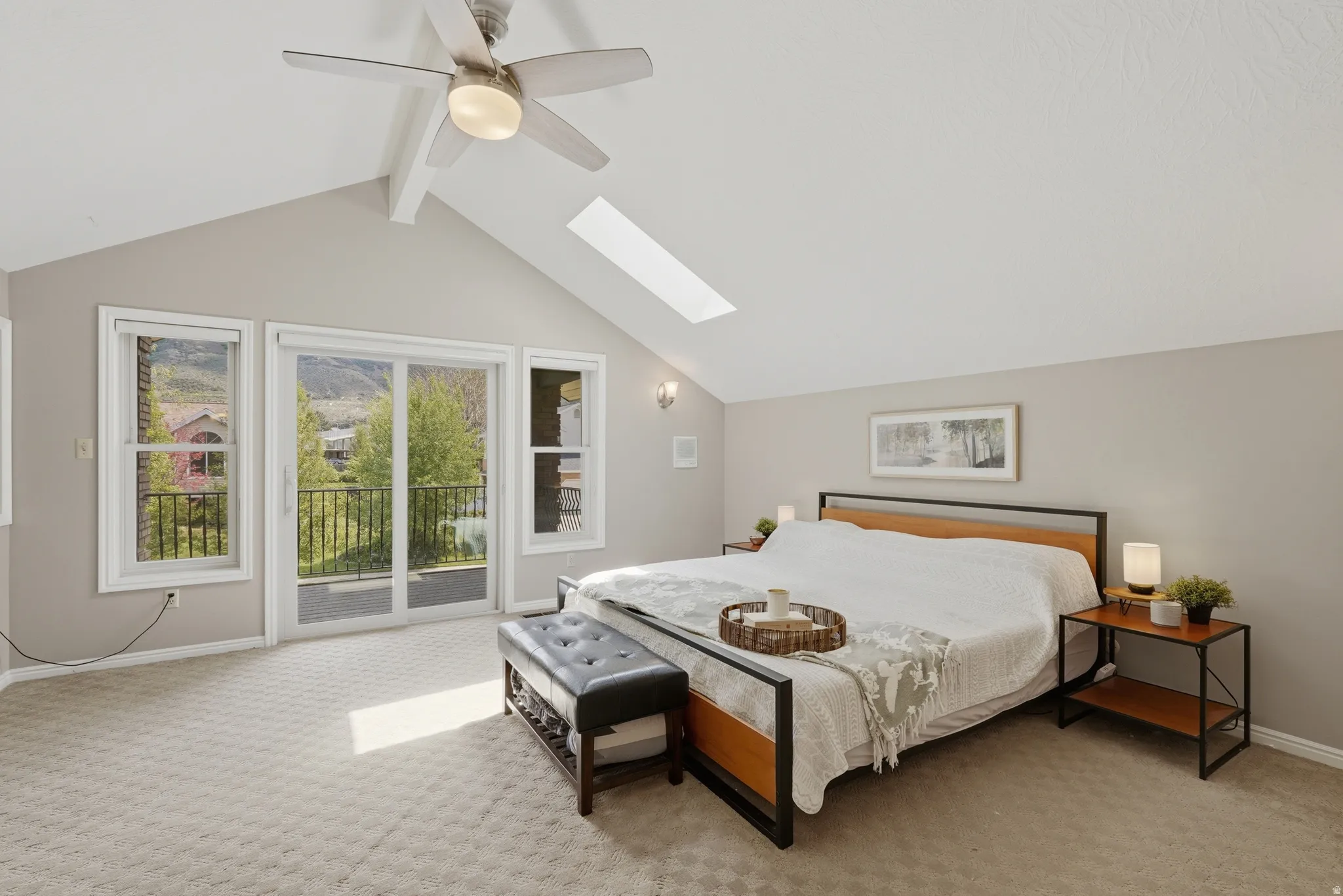 Primary Bedroom featuring a skylight, access to exterior balcony.
