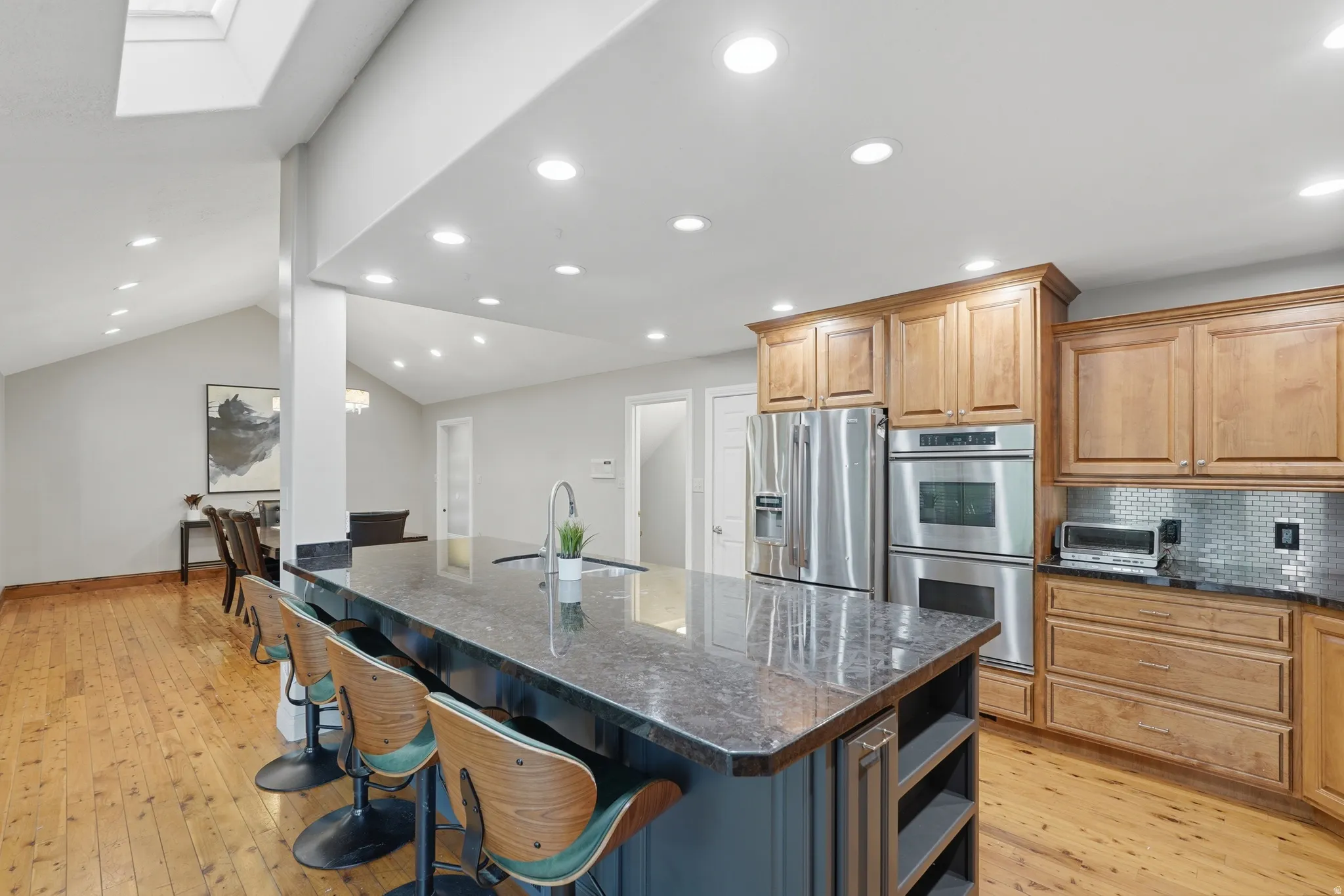 Dual tone kitchen featuring dual tone cabinets, 10' island,  granite counters, recessed lighting, and stainless steel appliances