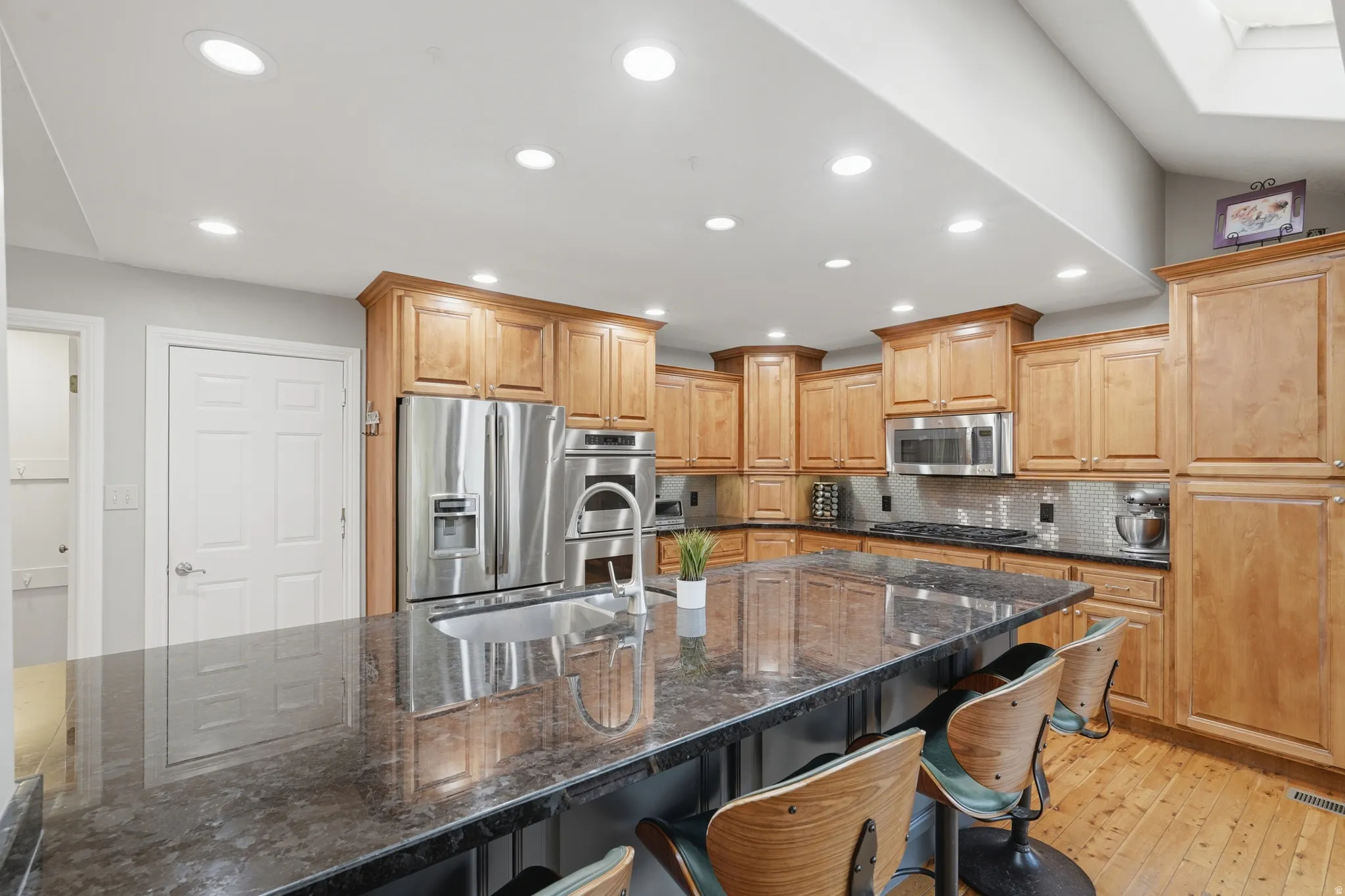 Dual tone kitchen featuring dual tone cabinets, 10' island,  granite counters, recessed lighting, and stainless steel appliances