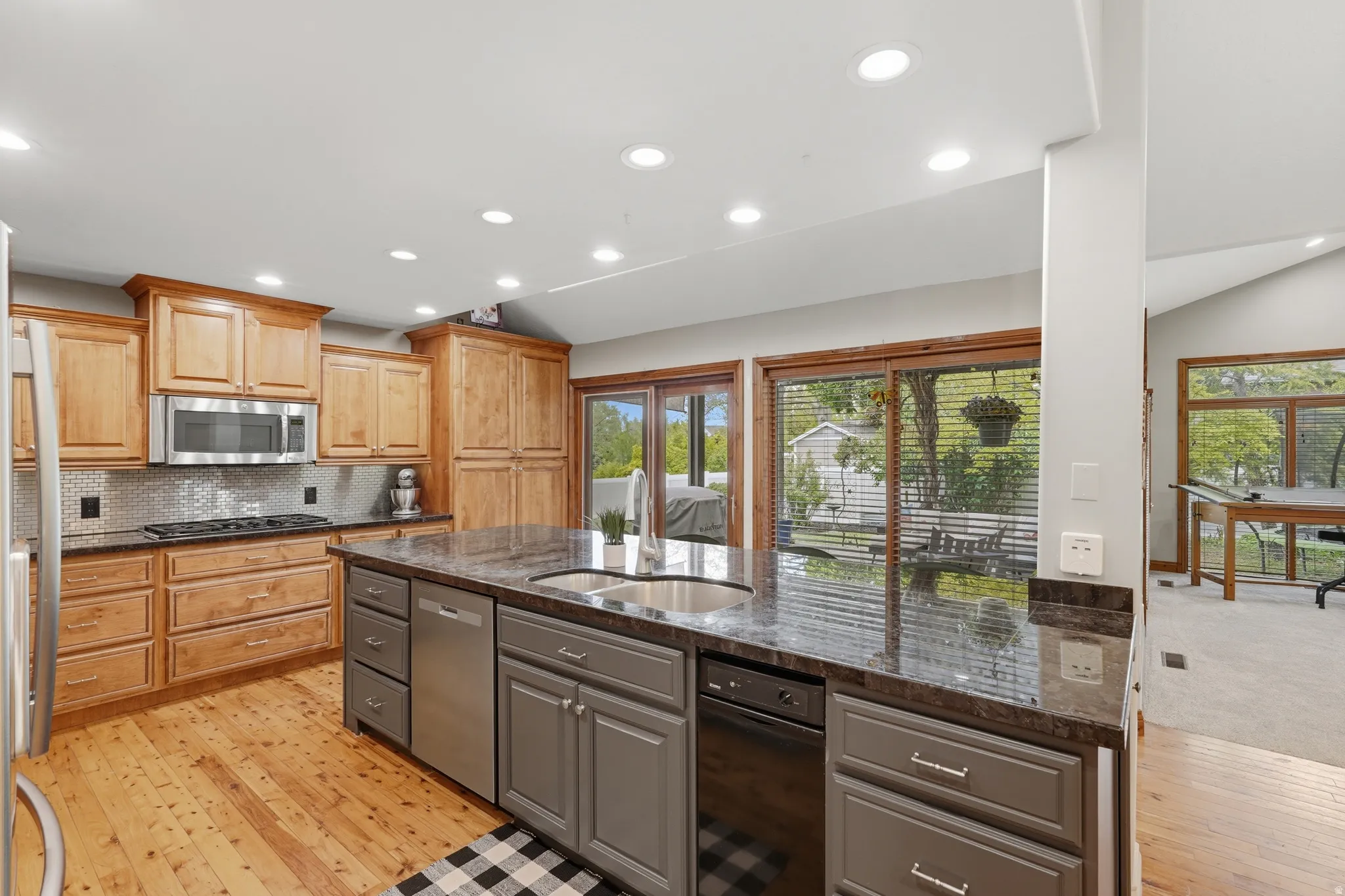 Dual tone kitchen featuring dual tone cabinets, 10' island,  granite counters, recessed lighting, and stainless steel appliances