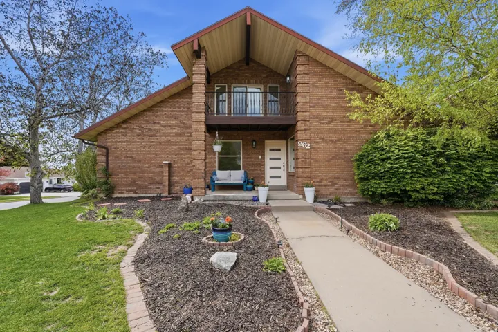 Entrance to property with brick siding and a yard
