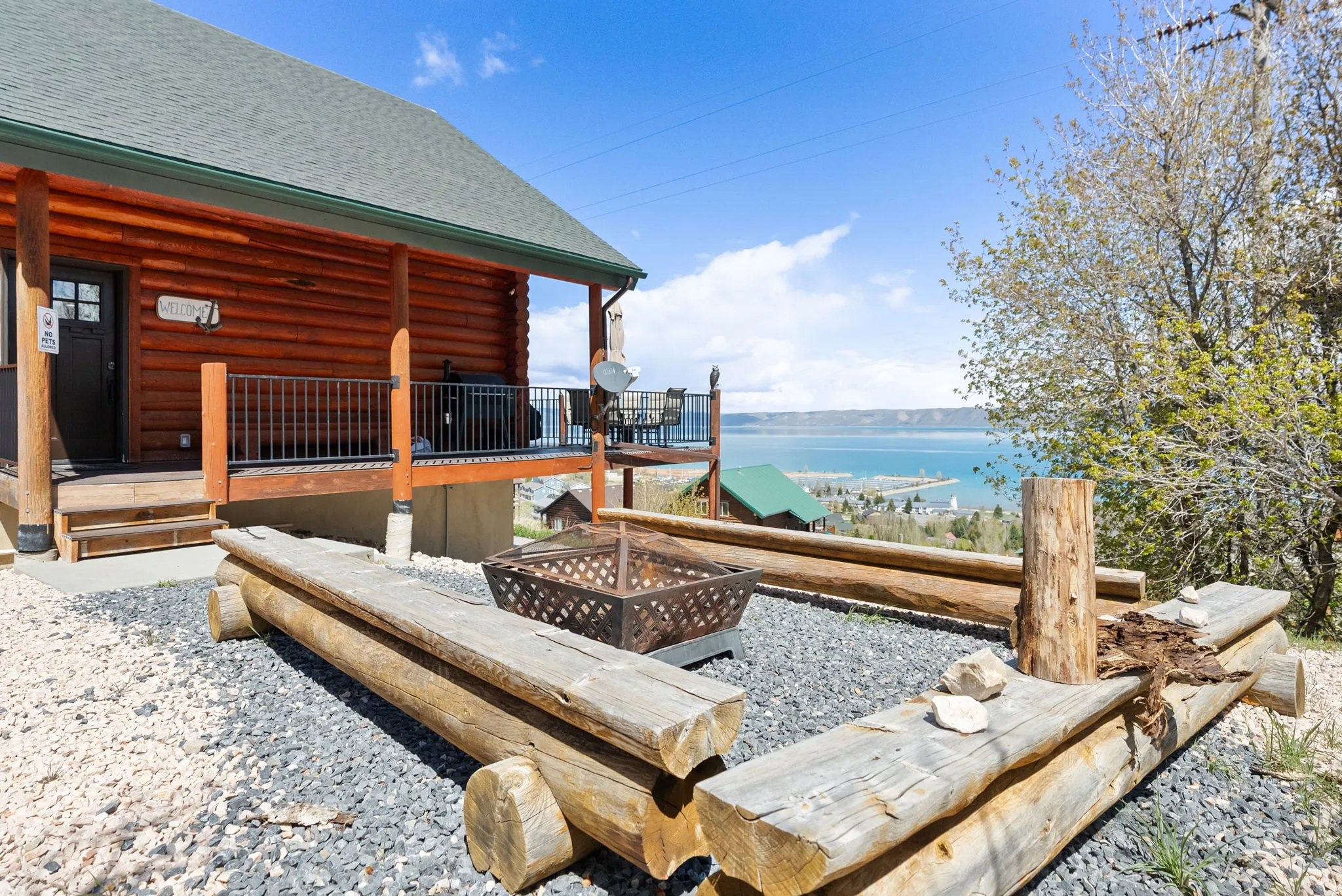Wooden deck featuring an outdoor fire pit and a water view