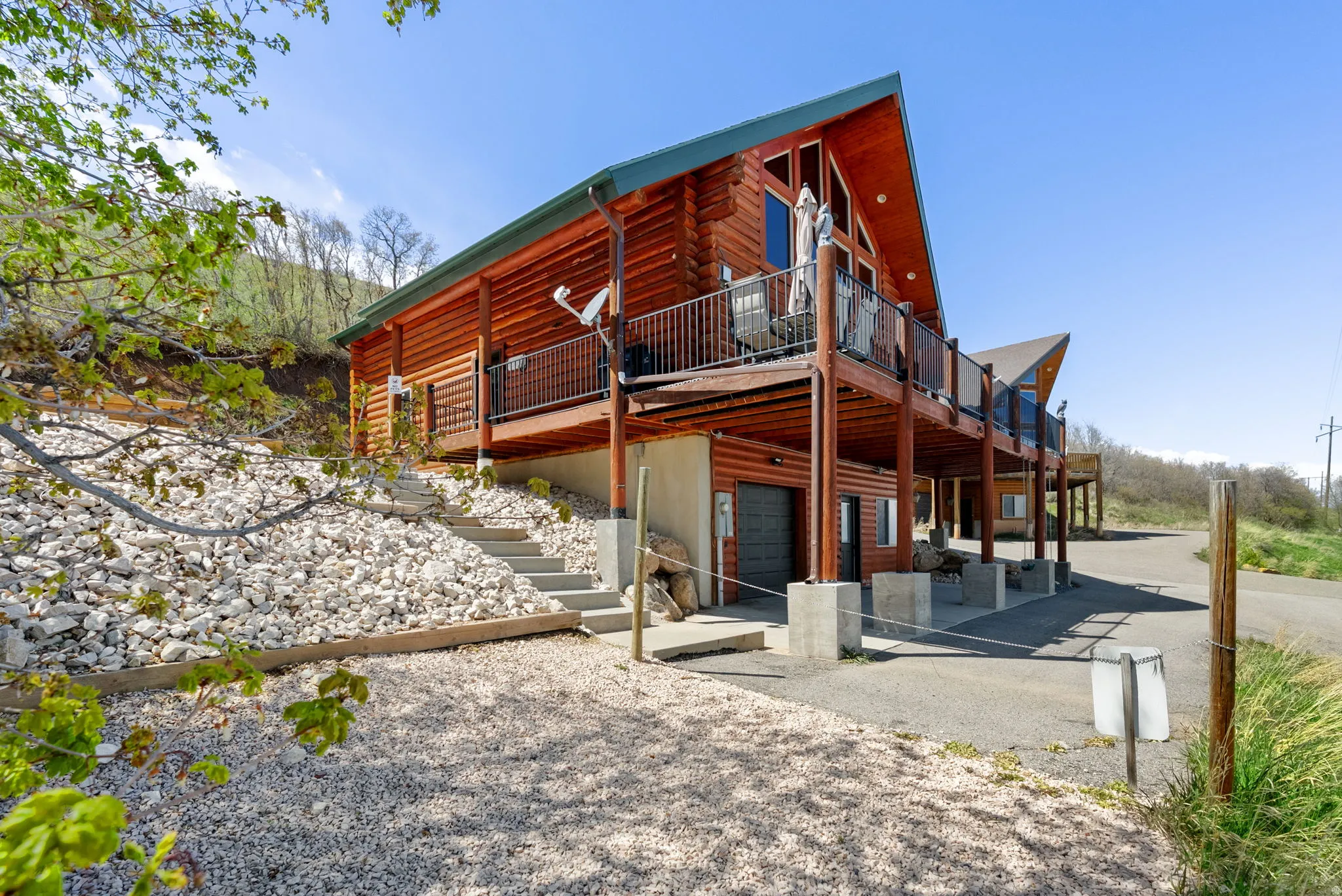Back of house with a deck and an attached garage