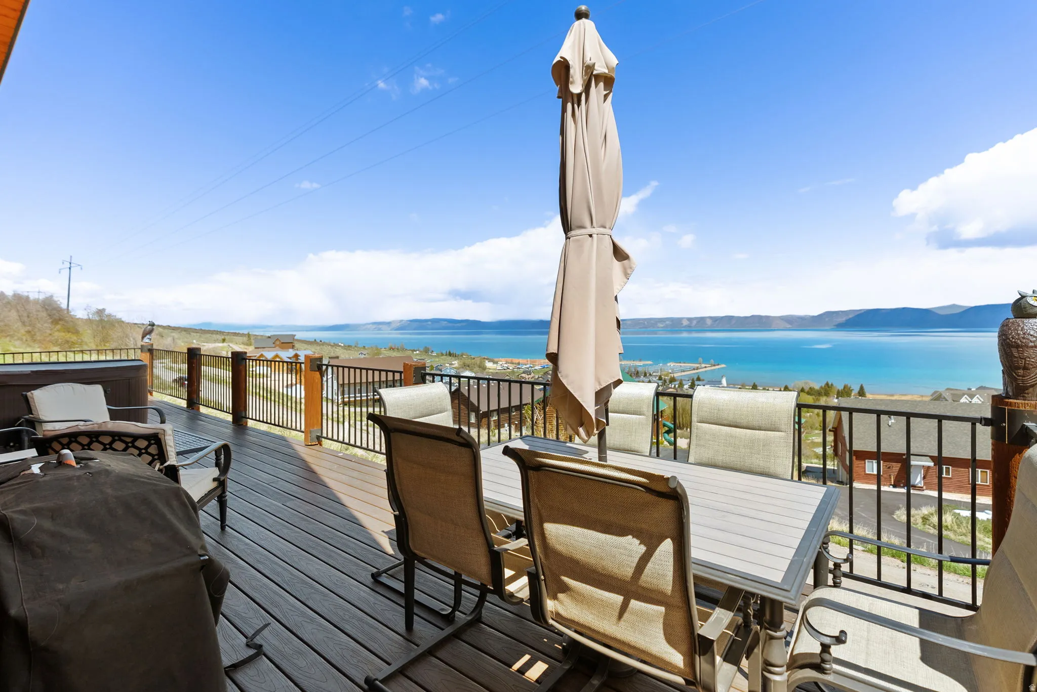 Deck with outdoor dining space, a water and mountain view, and grilling area