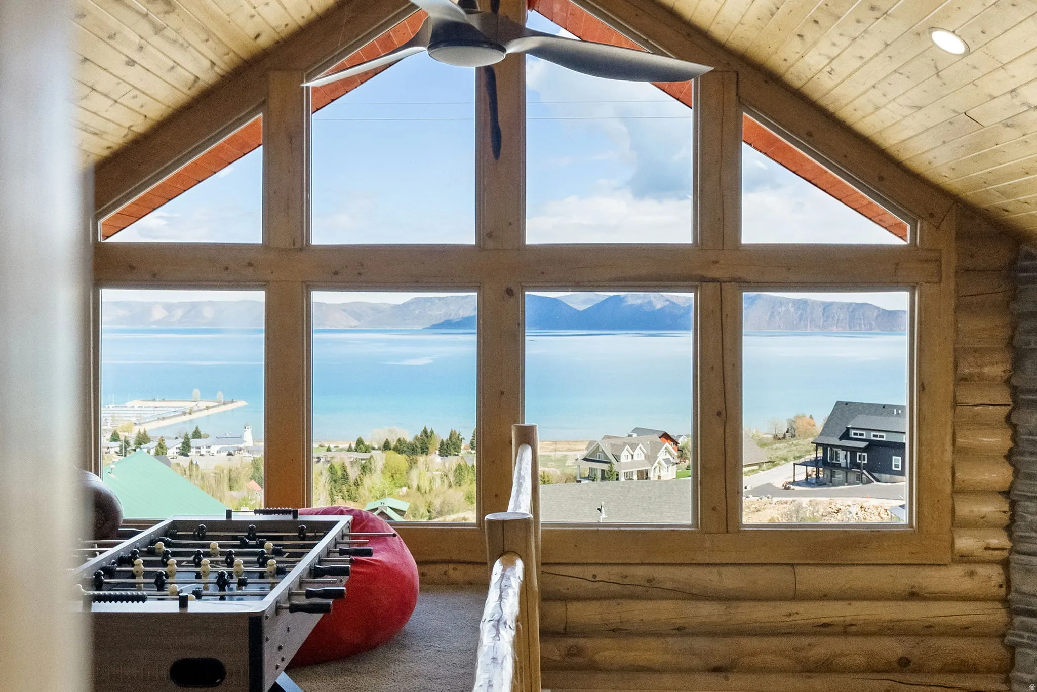 Rec room with a water view, plenty of natural light, and log walls