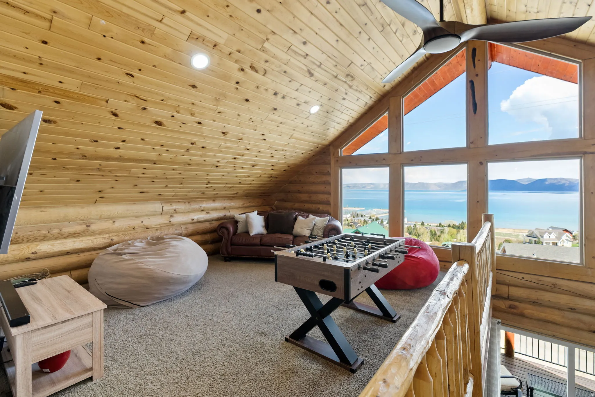 Playroom featuring log walls, wood ceiling, a water view, carpet flooring, and recessed lighting