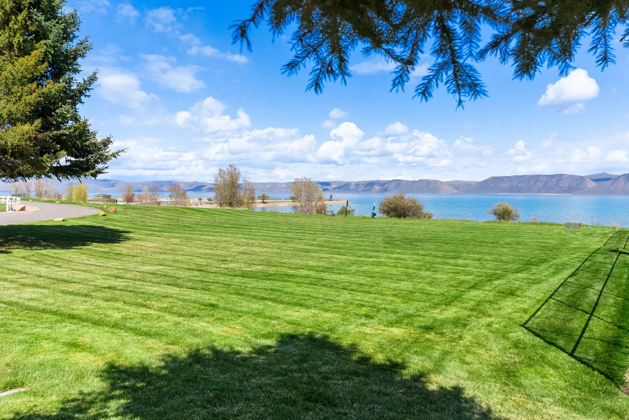 View of green lawn with a water and mountain view