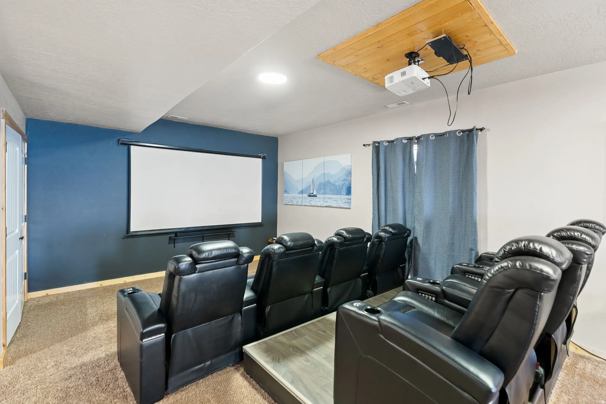 Home theater room featuring light carpet and a textured ceiling