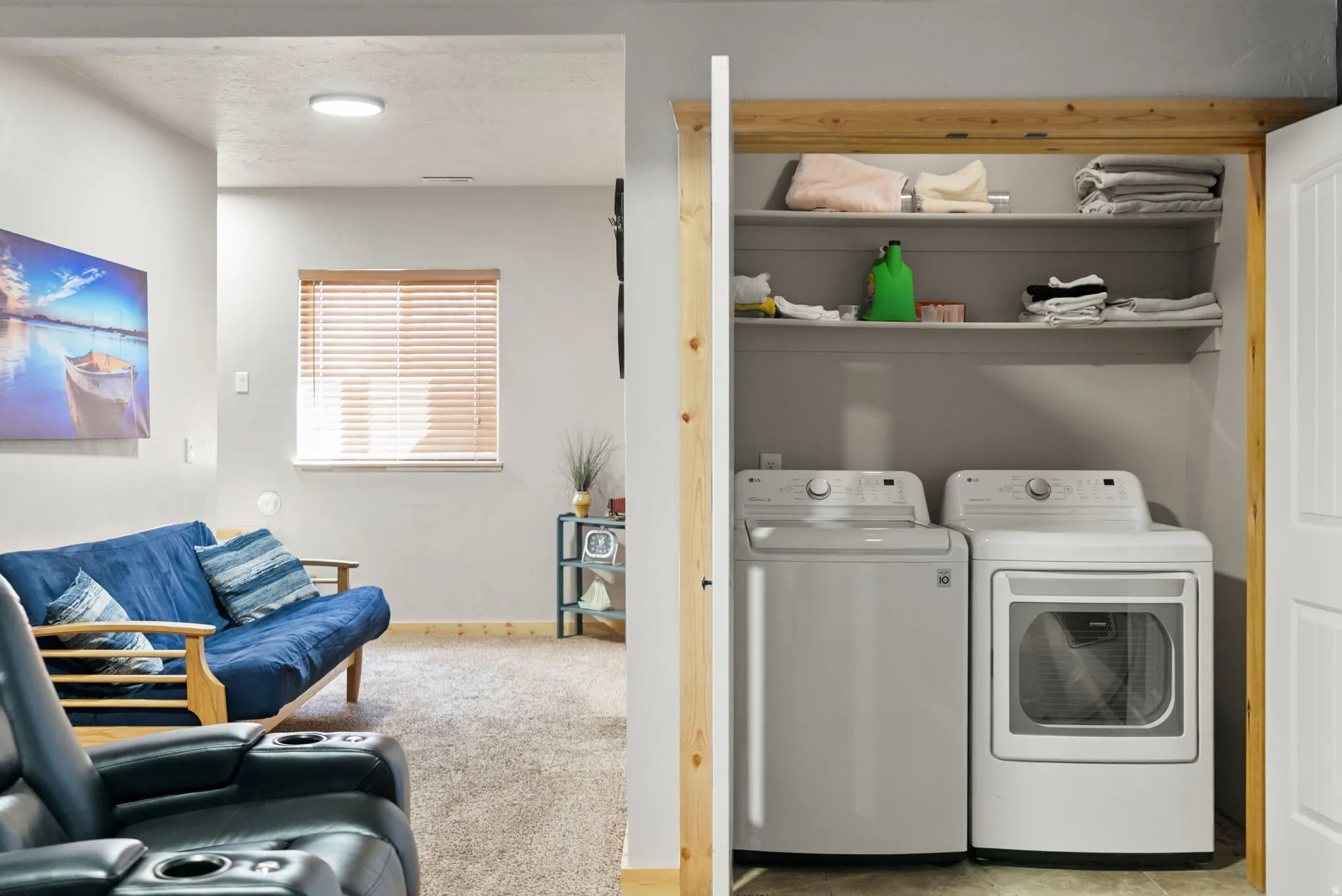 Laundry area with washing machine and dryer, light carpet, and a textured ceiling