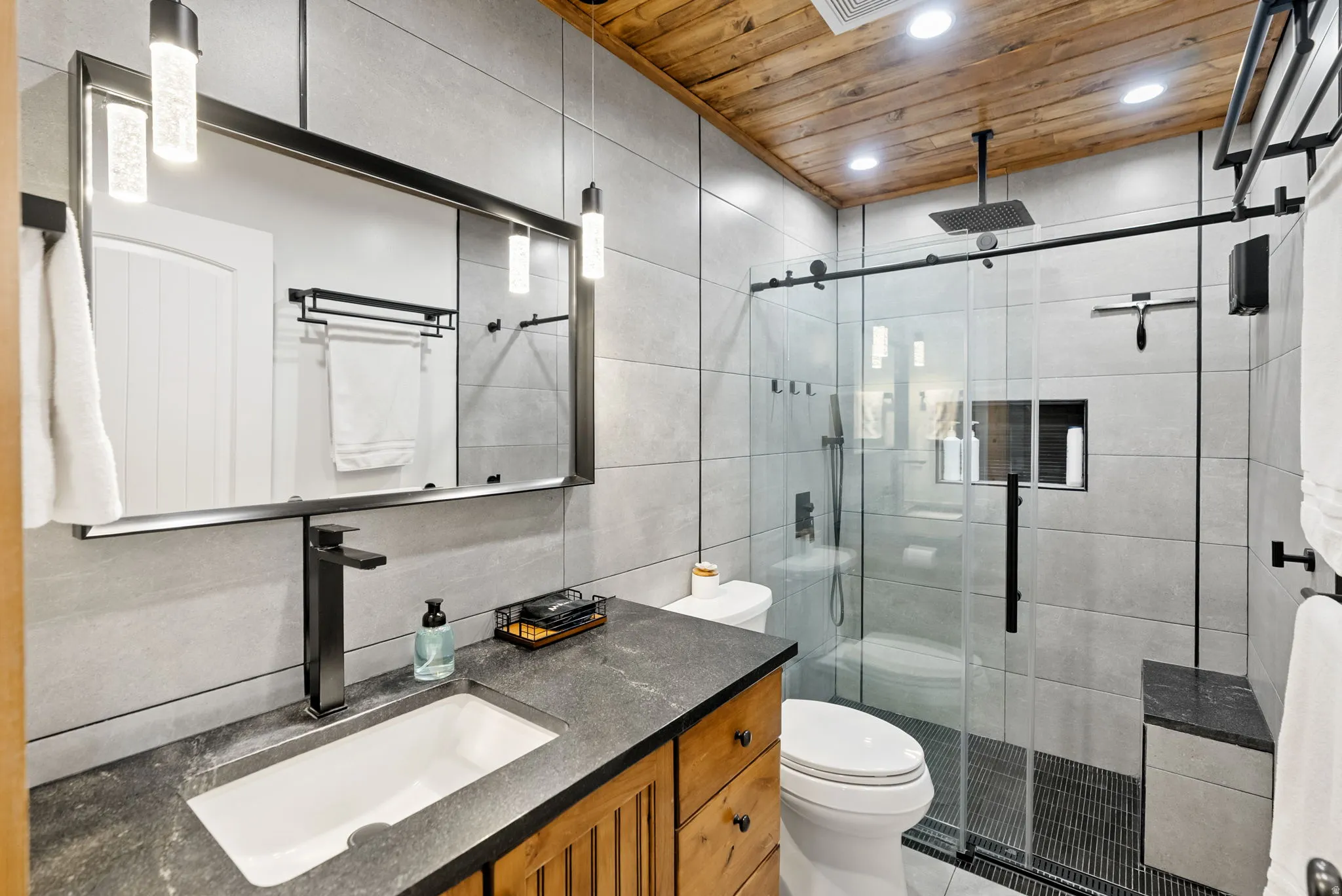 Bathroom featuring vanity, tile walls, a shower stall, wood ceiling, and recessed lighting