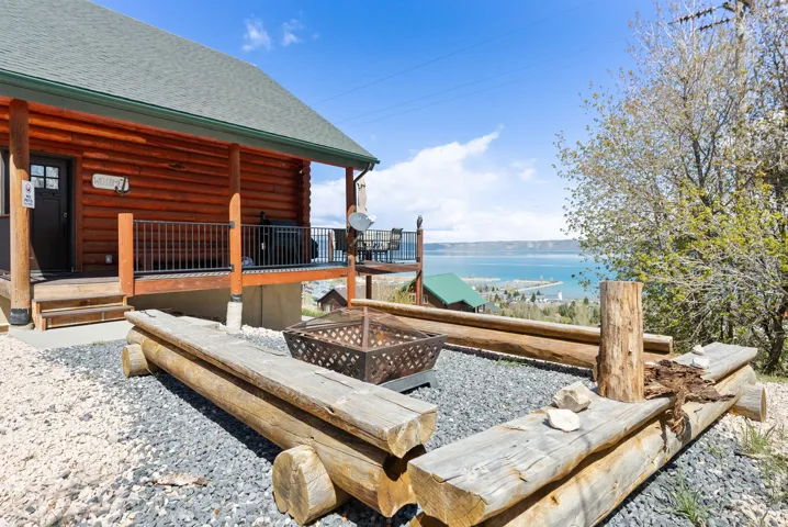 Wooden deck featuring an outdoor fire pit and a water view