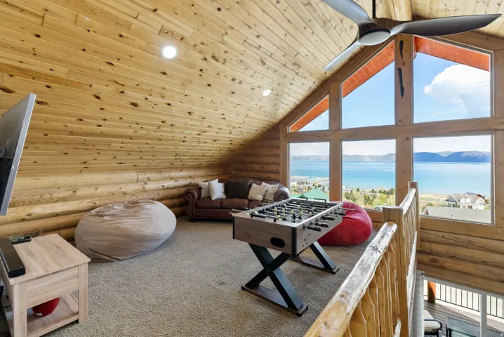 Playroom featuring log walls, wood ceiling, a water view, carpet flooring, and recessed lighting