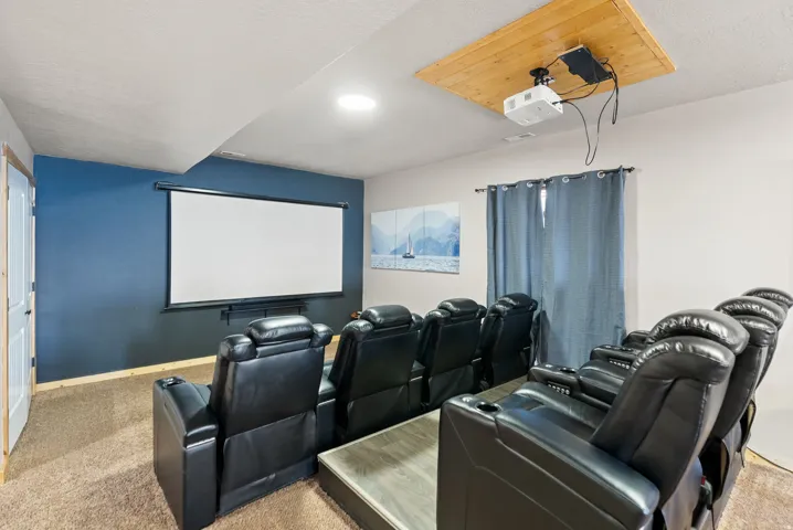 Home theater room featuring light carpet and a textured ceiling
