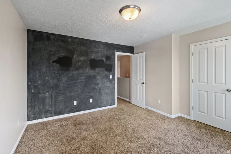 Unfurnished bedroom with carpet floors and a textured ceiling