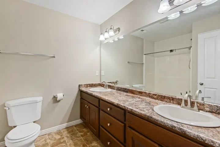 Full bathroom with double vanity and a shower