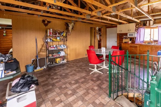Dining space featuring wood walls and brick patterned floors
