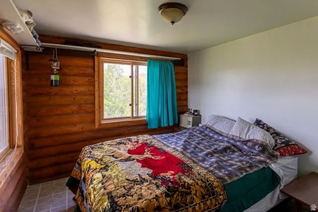 Bedroom featuring rustic walls