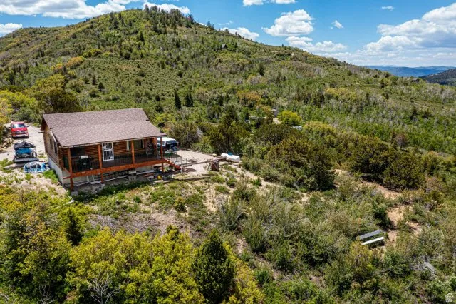 View of subject property featuring a mountainous background and a heavily wooded area
