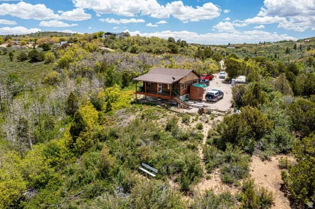 Aerial view of property and surrounding area with a heavily wooded area