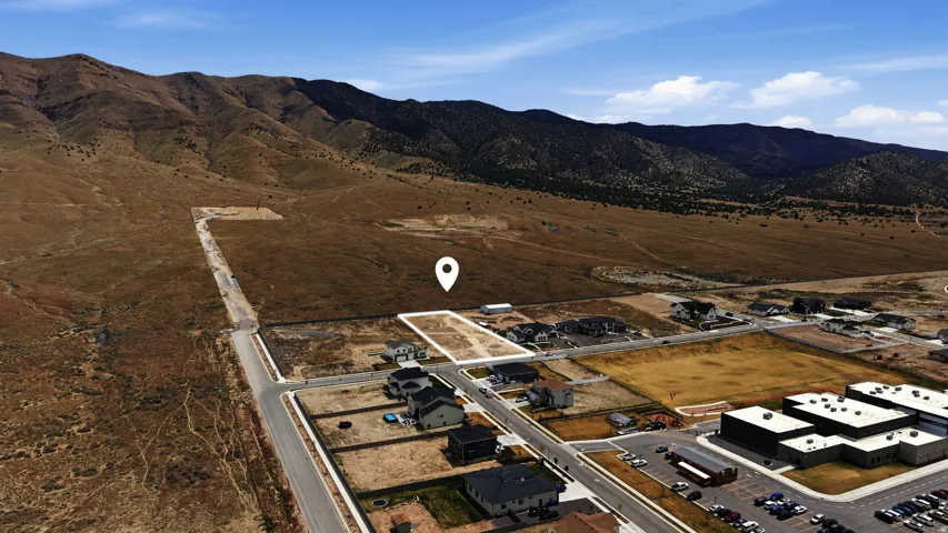 Aerial view of property and surrounding area featuring a mountain backdrop and rural landscape