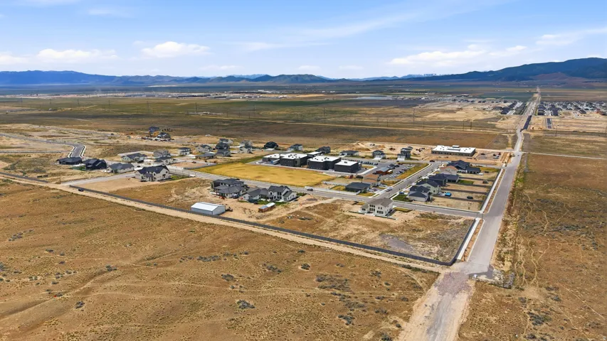 Aerial view of property's location with nearby suburban area, mountains, and rural landscape