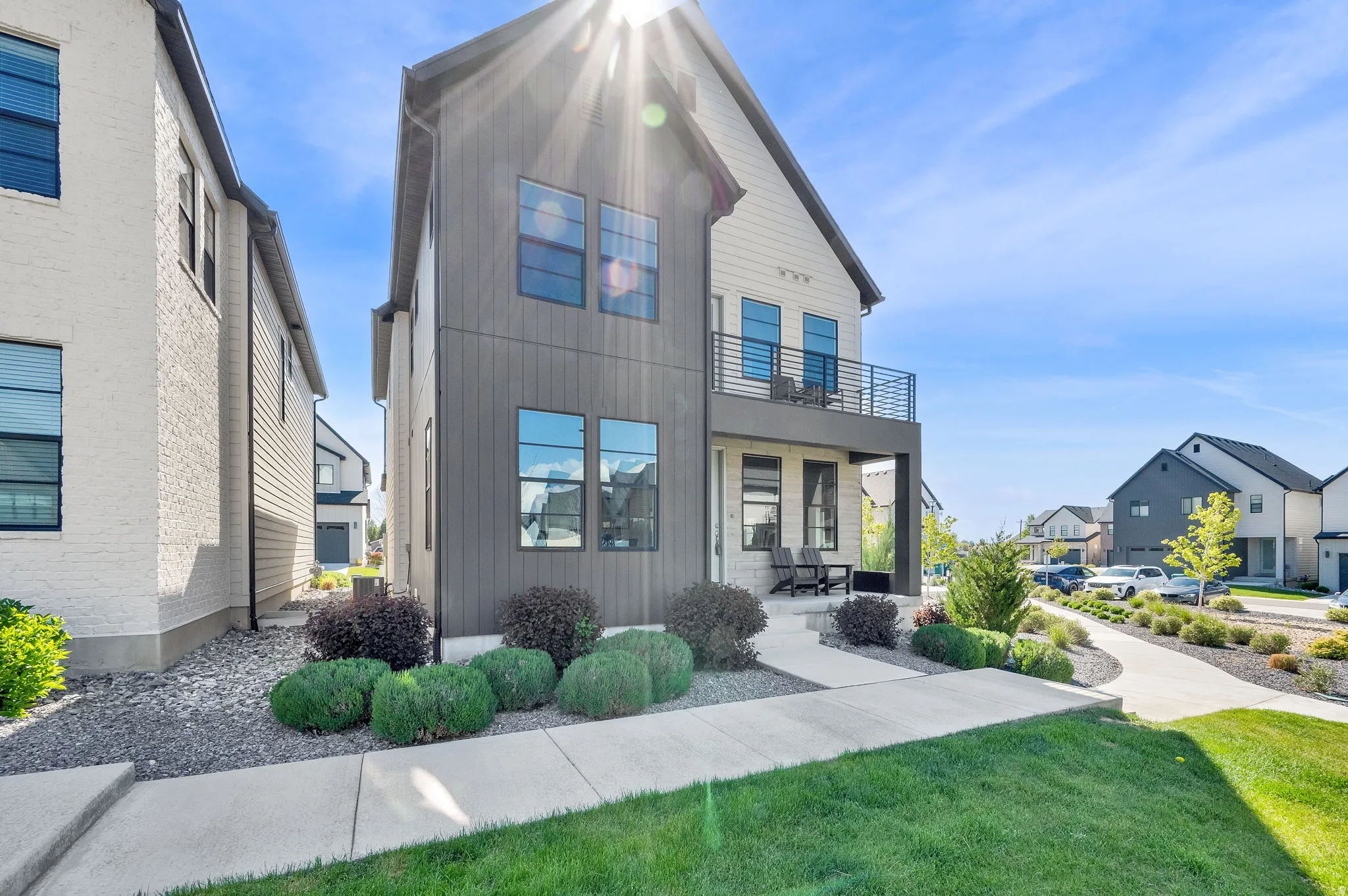 View of front of home featuring a balcony, a residential view, and a front yard