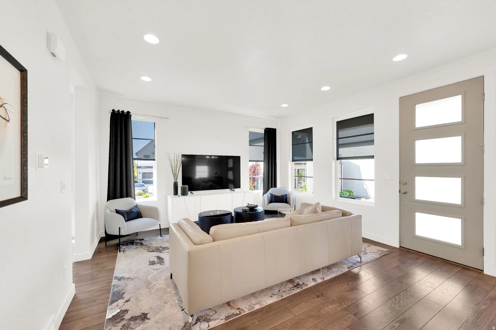 Living room with wood-type flooring and recessed lighting