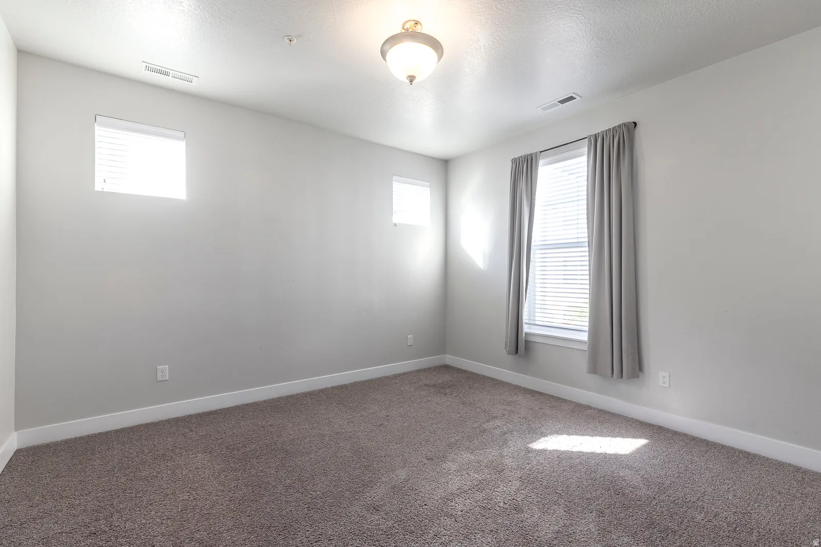 Spare room with healthy amount of natural light, carpet flooring, and a textured ceiling