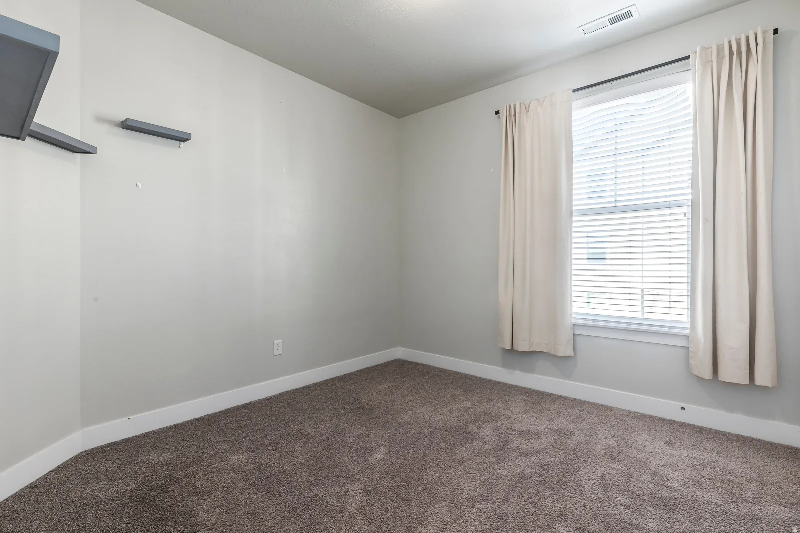 Unfurnished room with baseboards and dark colored carpet