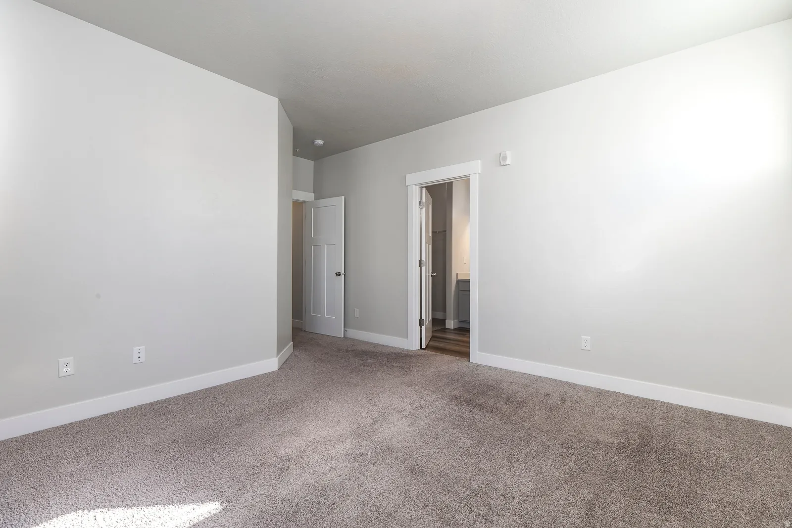 Unfurnished bedroom featuring carpet and ensuite bathroom