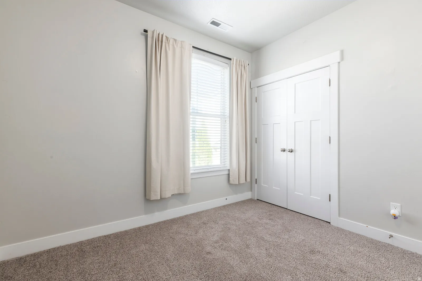 Unfurnished bedroom with carpet flooring and a closet